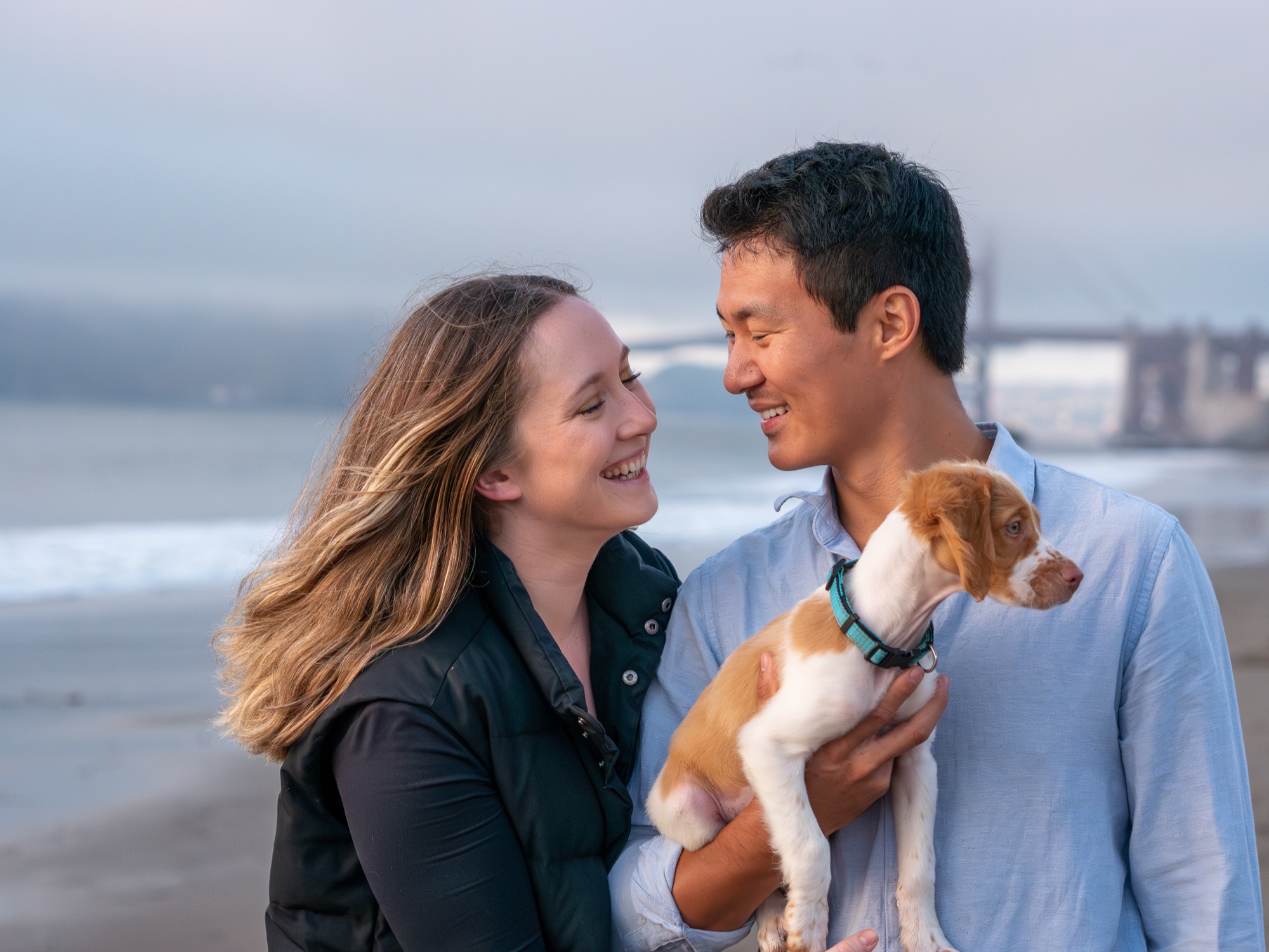 Puppy and owners with Golden Gate Bridge